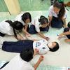 Classmates draw around the body of a student at a school in northern Thailand.