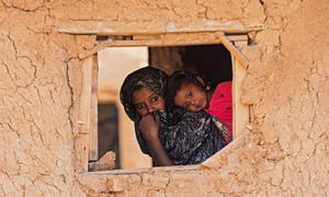 A child and mother peer through a window in Alsabaat community, Kassala state (file).