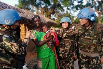 Des femmes soldats de la paix de l'ONU interagissent avec une femme et son bébé en République centrafricaine.