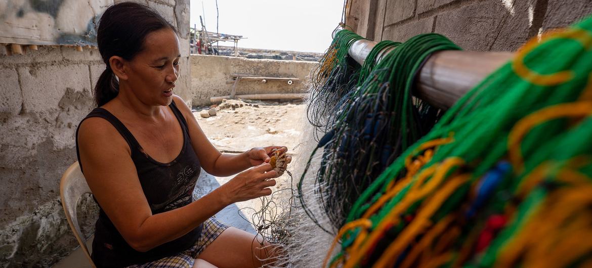Christina Guevarra removes crabs from fishing nets. Christina Guevarra removes crabs from fishing nets.