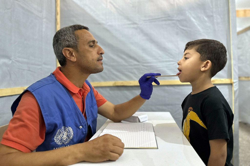 Un employé de l'UNRWA soigne un jeune garçon à Gaza.