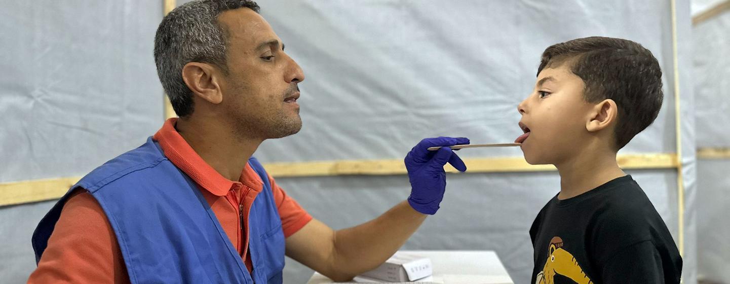Un employé de l'UNRWA soigne un jeune garçon à Gaza.