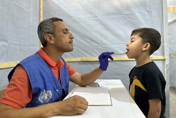 Un employé de l'UNRWA soigne un jeune garçon à Gaza.