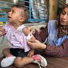 An UNRWA worker in Gaza checks a child for signs of malnutrition.