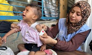 Una trabajadora de UNRWA en Gaza comprueba si un niño presenta signos de desnutrición.