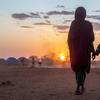 Une mère et son enfant marchent ensemble dans un camp de personnes déplacées en Éthiopie.
