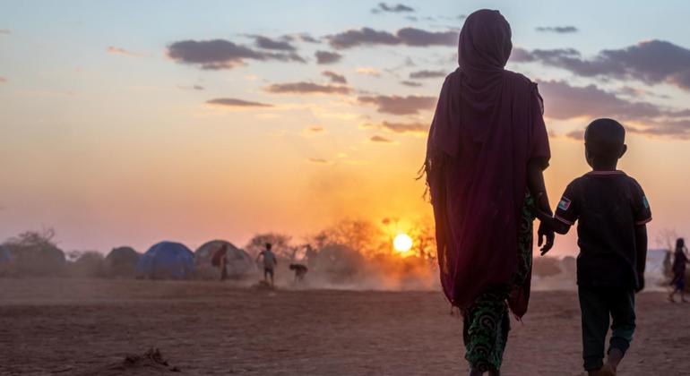 Une mère et son enfant marchent ensemble dans un camp de personnes déplacées en Éthiopie.