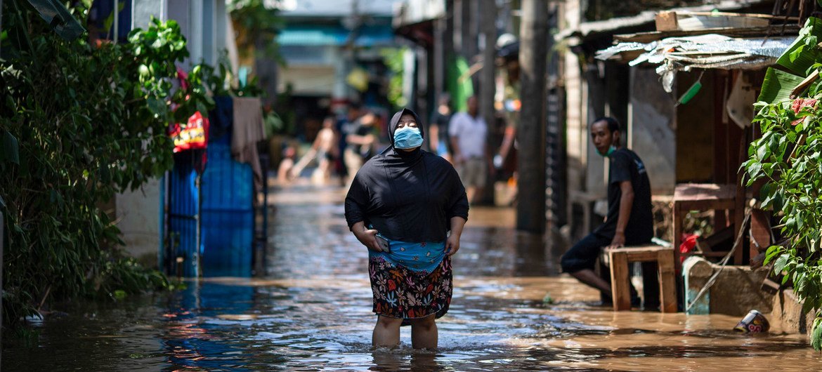 Mwanamke akiembea kwenye maji yaliyotuama katika eneo lililo athirika na mafuriko huko Masharki mwa Jakarta, nchini Indonesia 