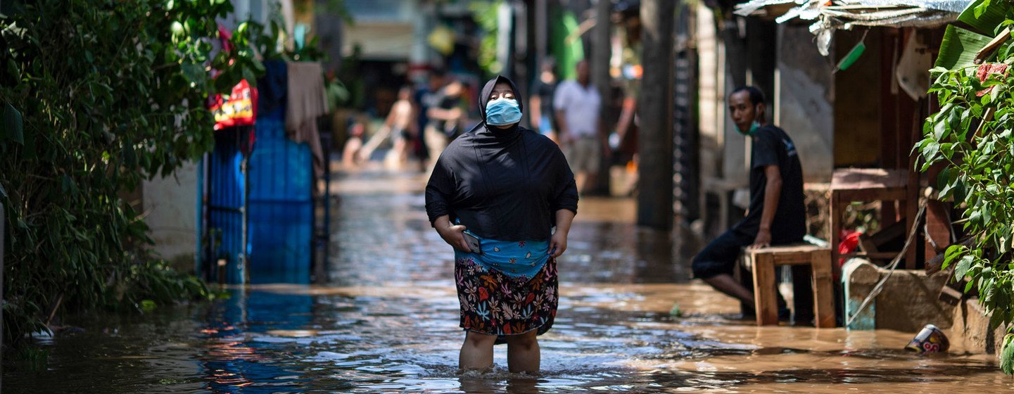 Una mujer camina a través de un área afectada por las inundaciones en el este de Jakarta, en Indonesia.