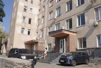A woman walks up the stairs to the entrance of a multi-story hospital building in Kyiv, Ukraine.