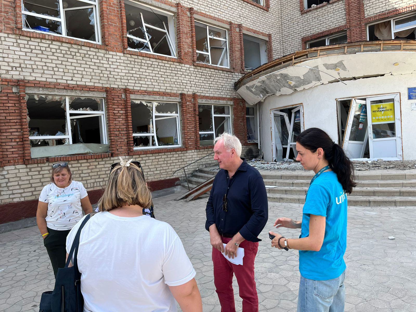 Le Coordinateur humanitaire pour l'Ukraine, Matthias Schmale (2e à partir de la droite), devant un centre de transit pour les personnes déplacées fuyant les hostilités dans la région de Donetsk, sur la ligne de front.