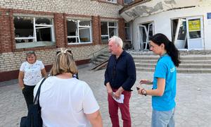 Humanitarian Coordinator for Ukraine Matthias Schmale (2nd from right) stands in front of a transit centre for displaced people fleeing hostilities in the front-line Donetsk Region.