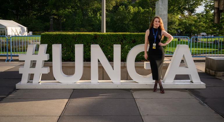 Mjumbe akipiga picha mbele ya ishara ya UNGA.