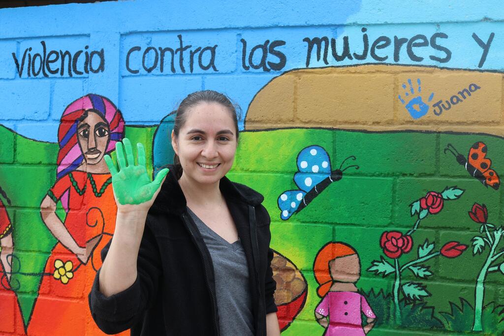 امرأة تشارك في رسم لوحة جدارية لرفع الوعي عن العنف ضد المرأة في هندوراس خلال 16 يوما من النشاط.