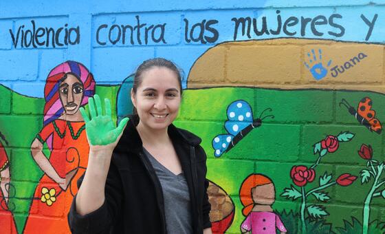 امرأة تشارك في رسم لوحة جدارية لرفع الوعي عن العنف ضد المرأة في هندوراس خلال 16 يوما من النشاط.