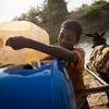 A boy collects water from a rehabilitated catchment basin in Sudan’s southern White Nile state.