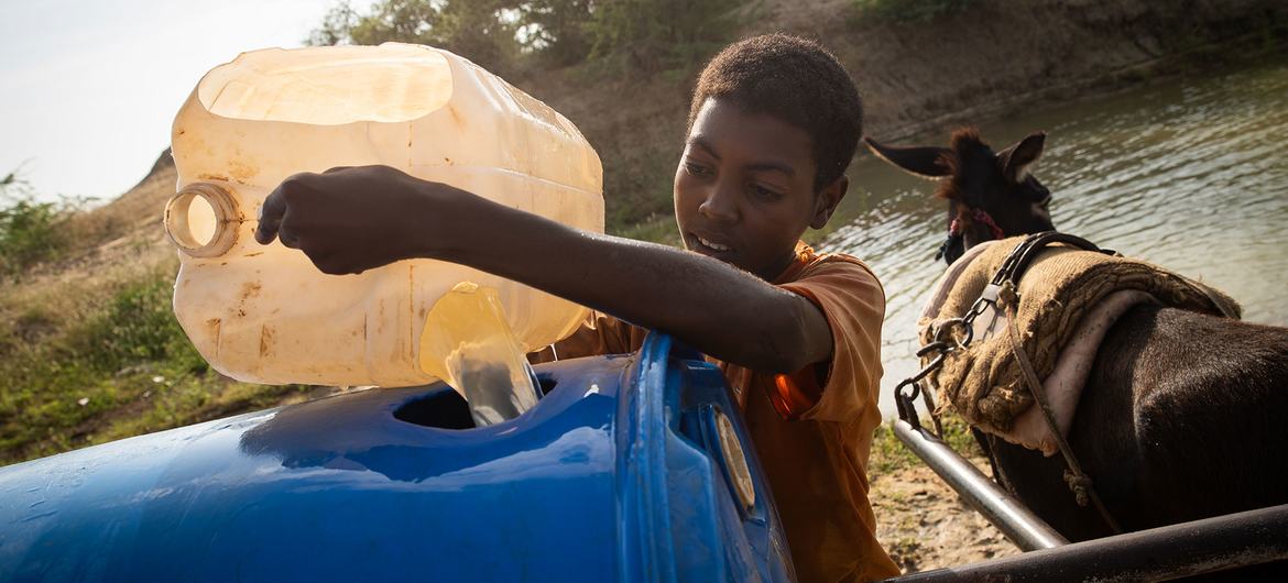 A boy collects water from a rehabilitated catchment basin in Sudan’s southern White Nile state.
