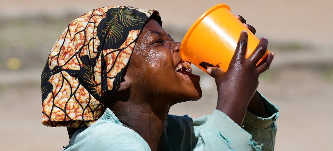 Uma menina bebe água na escola no Chade.