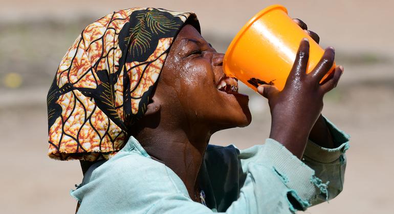 Uma menina bebe água na escola no Chade.