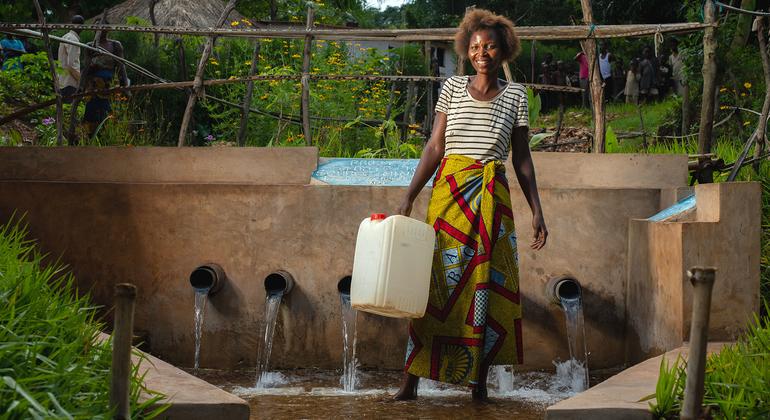 Mulher recolhe água numa fonte desenvolvida pelo Unicef na República Democrática do Congo.