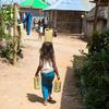 تیمور لیسٹے میں ایک چھ سالہ بچی اپنے گھر سے دور واقع نل سے پانی بھر کر لا رہی ہے۔ 