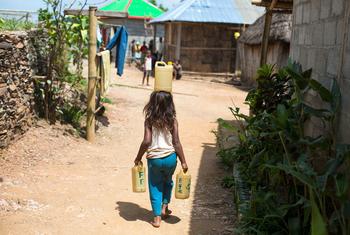  छह साल की एक लड़की, झरने से पानी ले जा रही है, जो तिमोर-लेस्ते में स्थित उसके घर से बहुत दूर है.