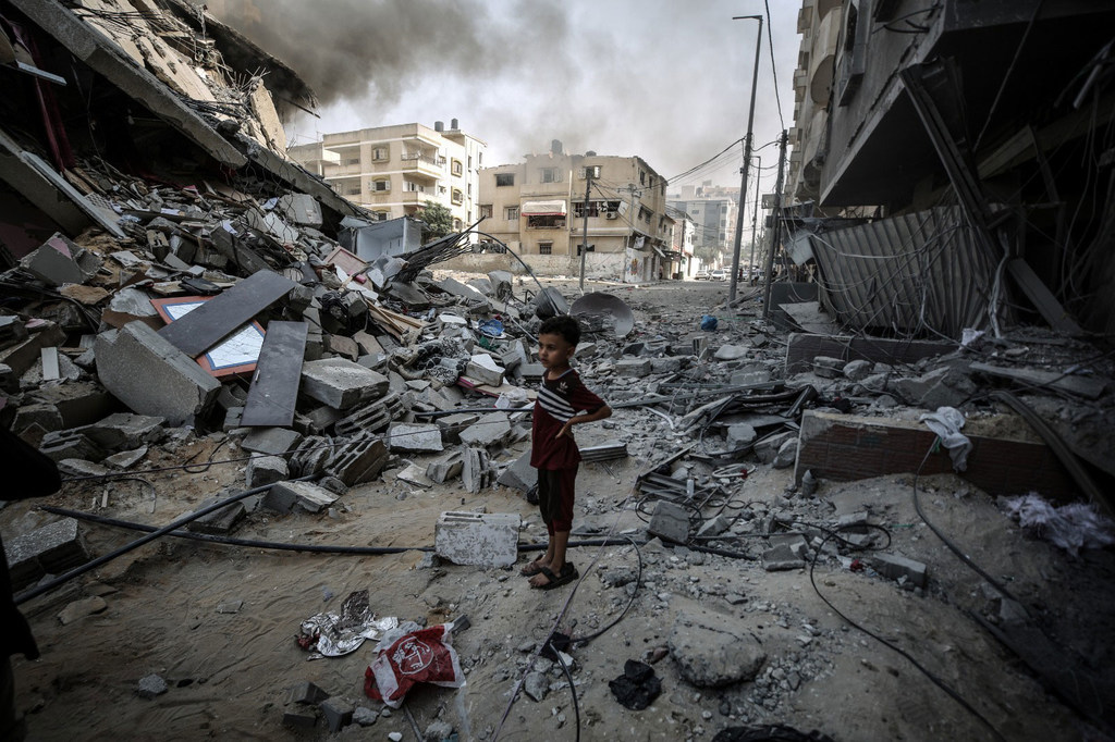 Un niño mira la destrucción causada por las bombas en su barrio de Gaza