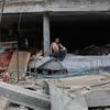 Un homme est assis dans un bâtiment gravement endommagé à Nuseirat, à Gaza (photo d'archives).