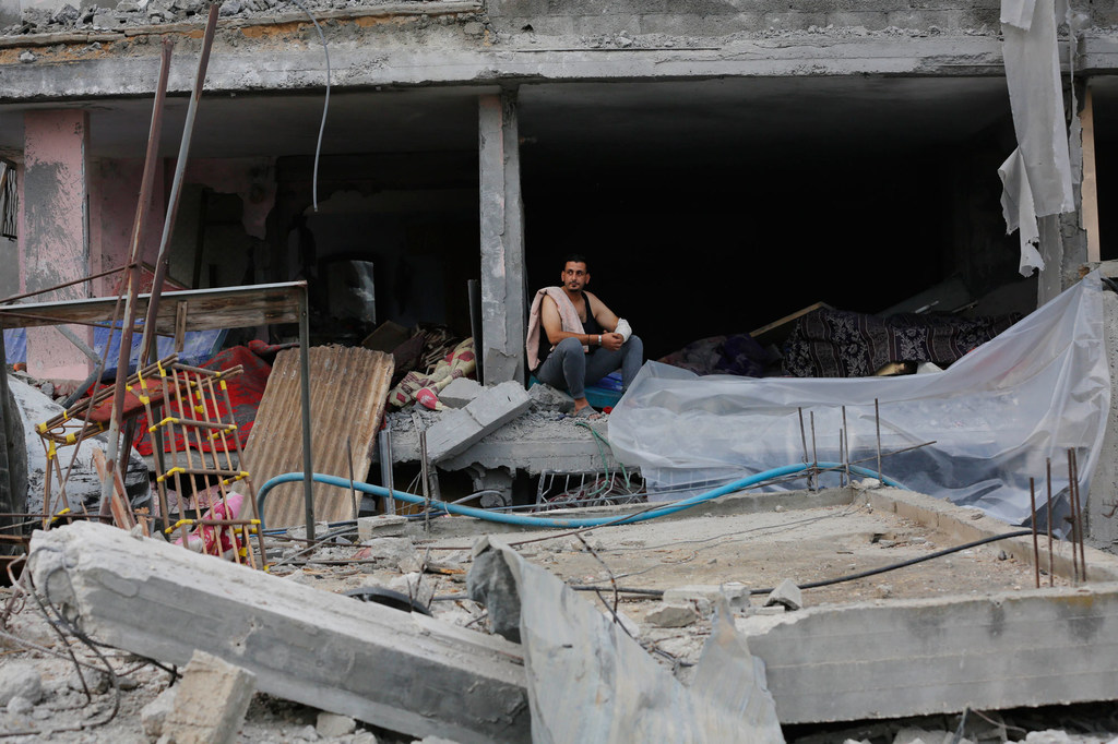 Un homme est assis dans un bâtiment gravement endommagé à Nuseirat, à Gaza (photo d'archives).