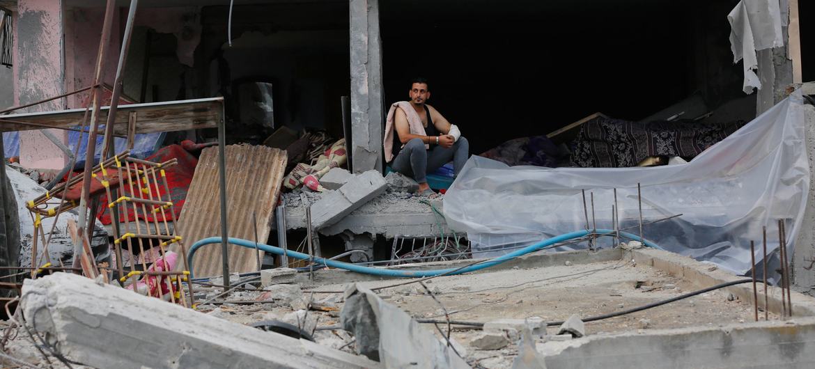 Un homme déplacé est assis au milieu des décombres d'un bâtiment fortement endommagé dans le camp de Nuseirat, à Gaza.
