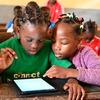Crianças aprendem com tablets na Escola Pública Melen de Yaoundé, Camarões. Globalmente, apenas 65% das mulheres do mundo estavam online em 2024, em comparação com 70% dos homens