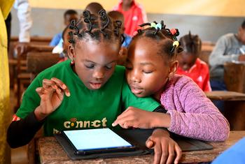 Crianças aprendem com tablets na Escola Pública Melen de Yaoundé, Camarões. Globalmente, apenas 65% das mulheres do mundo estavam online em 2024, em comparação com 70% dos homens
