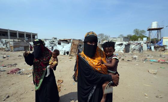 Mujeres cargando a sus hijos en un campo de desplazados por la violencia en Yemen.