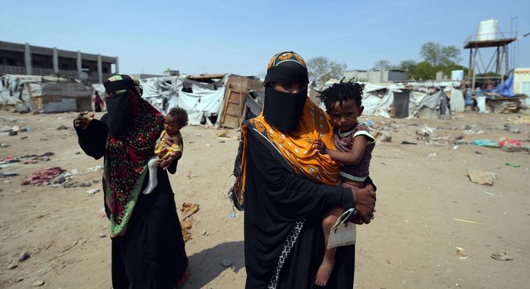 Mujeres cargando a sus hijos en un campo de desplazados por la violencia en Yemen.