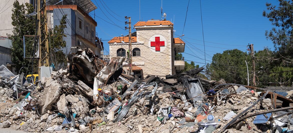 Una calle en Tebnine, en el sur del Líbano, está llena de escombros y restos de edificios dañados por las hostilidades. En el fondo, el Hospital Gubernamental de Tebnine, con el símbolo de la Cruz Roja, muestra en su estructura y en el área circundante signos de daños por el conflicto.