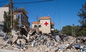 Una calle en Tebnine, en el sur del Líbano, está llena de escombros y restos de edificios dañados por las hostilidades. En el fondo, el Hospital Gubernamental de Tebnine, con el símbolo de la Cruz Roja, muestra en su estructura y en el área circundante signos de daños por el conflicto.