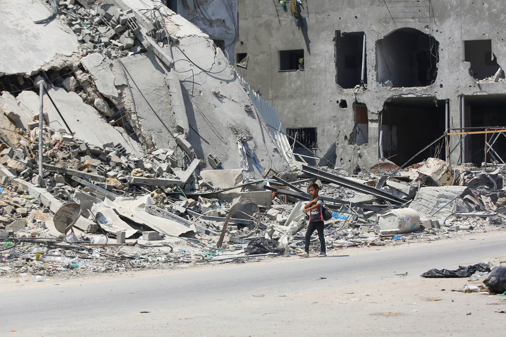 Un enfant marchant dans les ruines de Gaza.