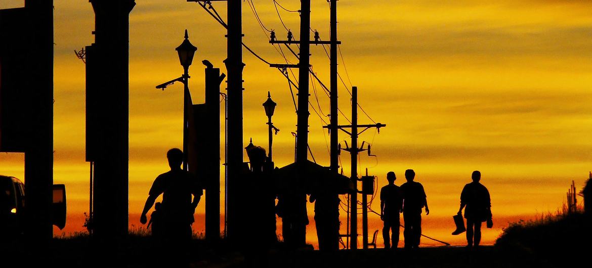 Trabalhadores da construção civil caminham por uma estrada em Daan Hari, Filipinas