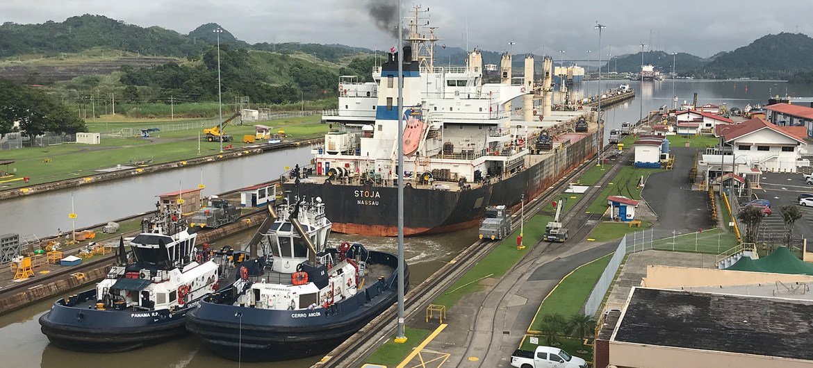 一艘船穿过巴拿马运河的航道，这是世界上最繁忙的贸易路线之一。