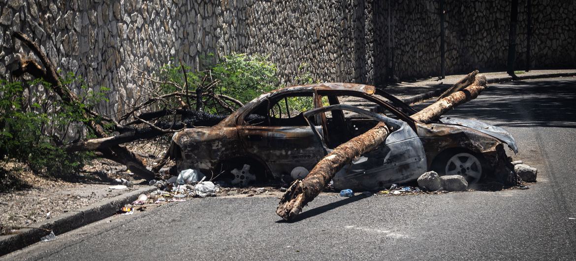 Un coche quemado sirve de barricada en una calle de Puerto Príncipe. Con más de 150 bandas operando en el país y sus alrededores, todas las carreteras de acceso y salida de la capital de Haití están ahora bajo el control de alguna banda.
