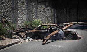 A burnt-out car serves as a barricade on a street in Port-au-Prince. With over 150 gangs operating in and around the country, all roads access in and out of Haiti's capital are now under some gang control.