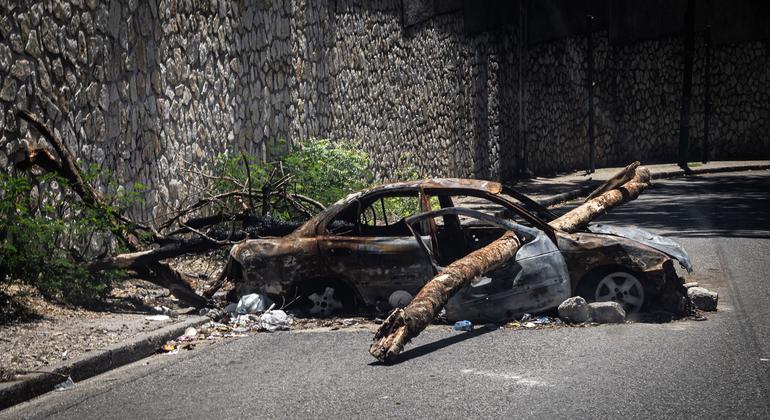Un coche quemado sirve de barricada en una calle de Puerto Príncipe. Con más de 150 bandas operando en el país y sus alrededores, todas las carreteras de acceso y salida de la capital de Haití están ahora bajo el control de alguna banda.