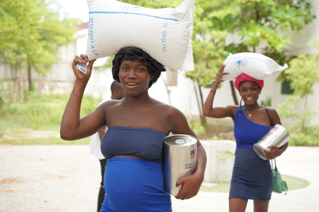 Des femmes en Haïti transportent de la nourriture distribuée par le PAM.