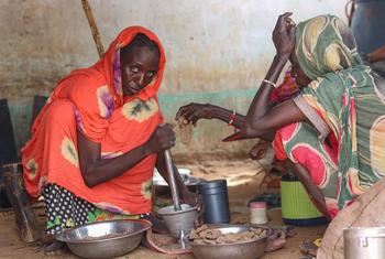 A woman prepares a meal for her family in El Fasher, North Darfur where people are trapped due to fighting