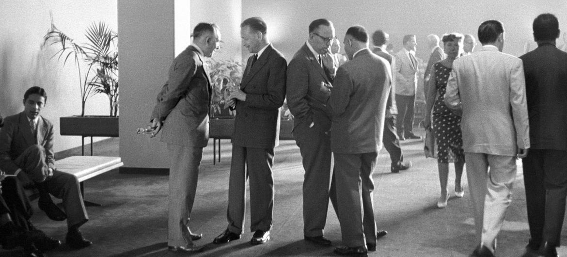 The then UN Secretary-General Dag Hammarskjöld (standing second from left) in conversation in the Delegates Lounge at UN Headquarters following an emergency special session in 1958.