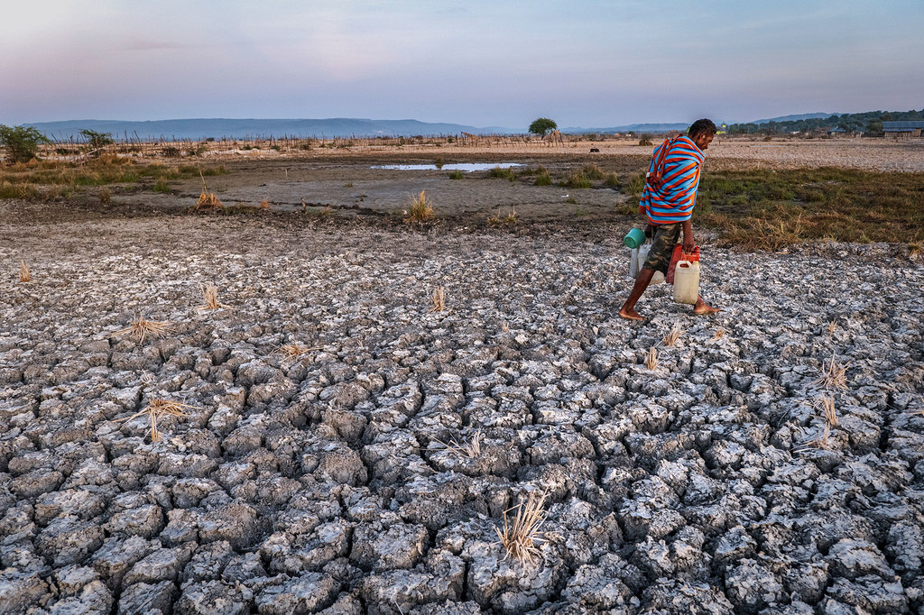 Um homem atravessa terras agrícolas secas na província de East Nusa Tenggara, Indonésia.