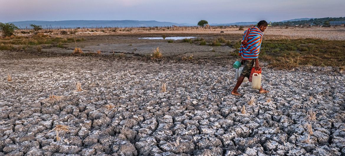 A man crosses parched farmland in East Nusa Tenggara Province, Indonesia