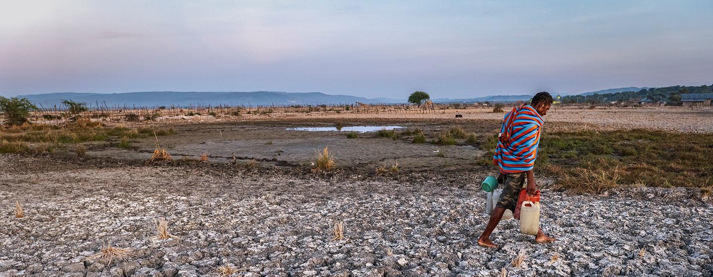 A man crosses parched farmland in East Nusa Tenggara Province, Indonesia