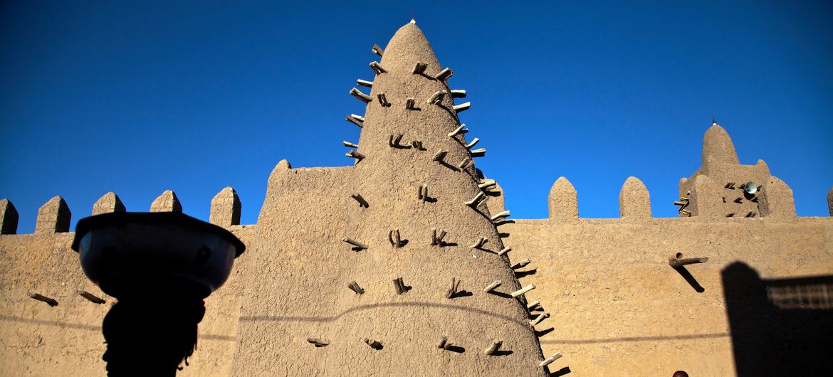 Os moradores de Timbuktu passam pela Mesquita Djingareyber, uma das estruturas arquitetônicas mais antigas que rendeu à cidade o status de Patrimônio Mundial da UNESCO.