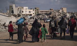 Displaced Palestinians walk through the destruction in Rafah in southern Gaza.